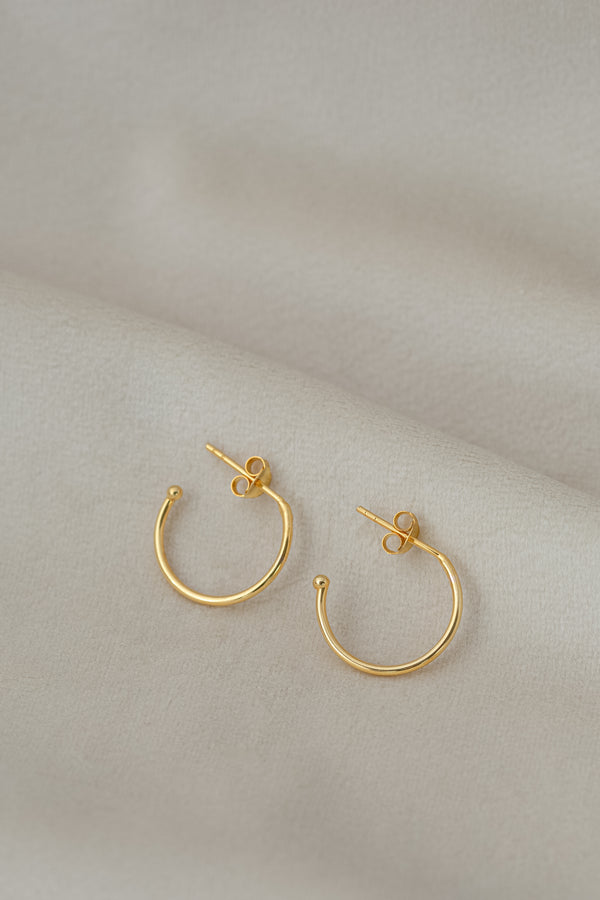 Golden hoop earrings Ava on textile