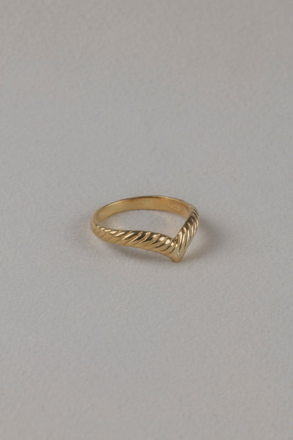 Golden knuckle ring Ada on textile